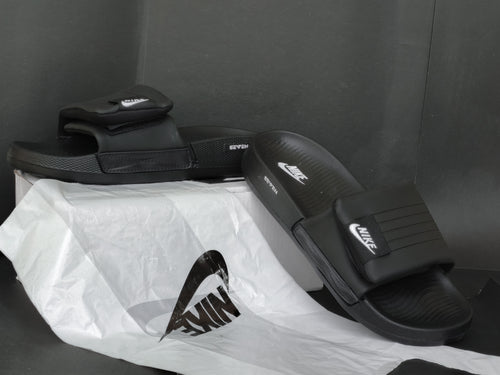 Black Nike slides on a white plastic bag with a dark background